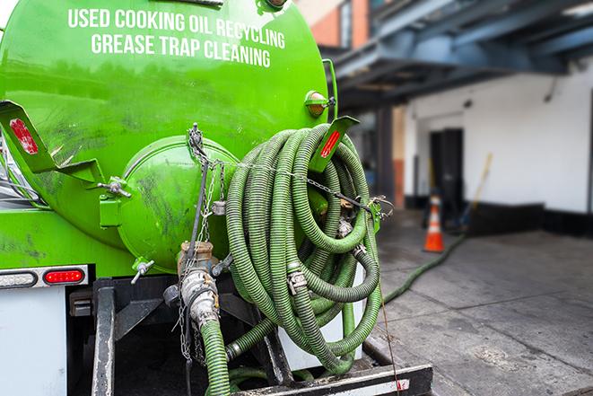 a grease trap being pumped by a sanitation technician in Elm Grove